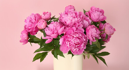 Vase with fresh peonies on pink background