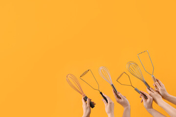 Female hands holding different whisks and mashers on yellow background