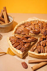 Tasty pecan pie on orange background