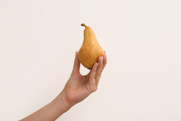 Woman holding ripe pear on white background