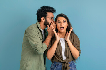Indian guy sharing secret with his shocked pretty girlfriend