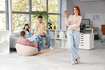 Fototapeta premium Young woman having coffee break in office