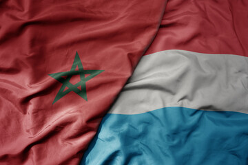 big waving national colorful flag of luxembourg and national flag of morocco .