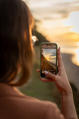 Picture in picture sunset photo of a woman's phone