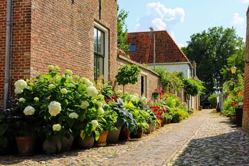 a cobblestone street with pots full of flowers next to an old brick building