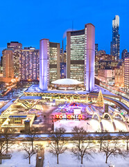 Night time view of Toronto City Hall and staking rink at Nathan Philips Square in winter