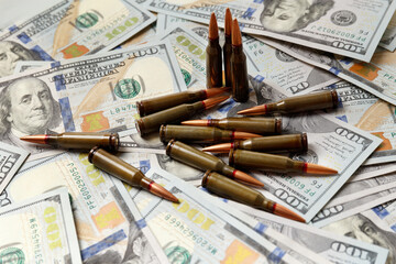 Bullets lie on American dollar bills, arms trade - obrazy, fototapety, plakaty