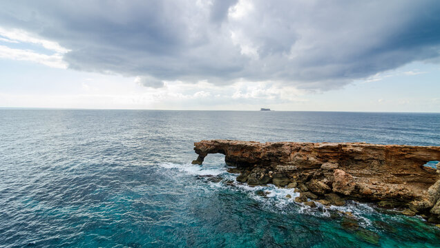 Typical rocky Malta coastline. Arch Ras il-Hamrija (Ghar Hanex) and Filfla island near Hagar Qim and Mnajdra, Malta