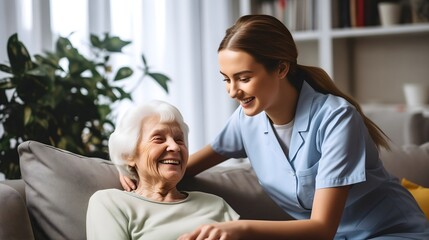 Beautiful young medical nurse in light blue uniform helping an elderly senior old woman patient with gray hair smiling. Female pensioner post surgery assistance, home nursing caregiver concept