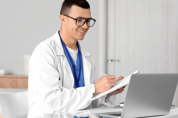 Young doctor video chatting with patient on laptop at home