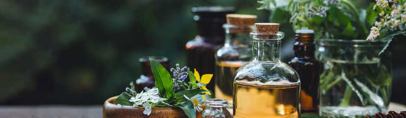 Concept of alternative herbal medicine. Bottles of tincture or potion, organic essential oils,...