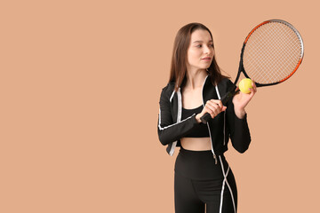 Sporty young woman with tennis racket on beige background