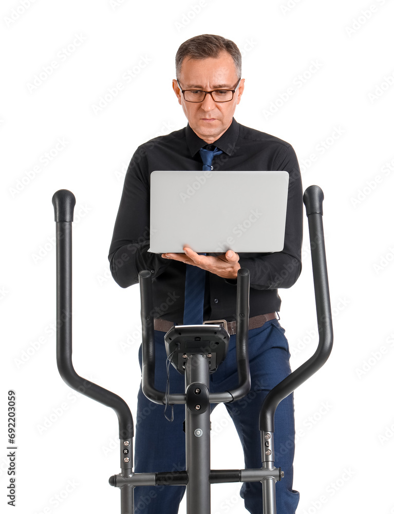 Poster Mature businessman using laptop on exercising bike against white background