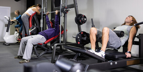 Fototapeta na wymiar Multiple people using fitness machines in gym