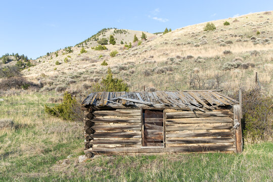 Abandoned and broken down ramshackle old antique homesteader log cabin home