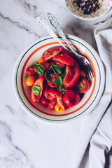 Healthy salad with different types of tomatoes and basil 