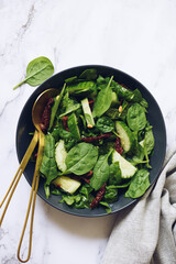 Healthy salad with spinach, cucumber, sun-dried tomatoes and pine nuts