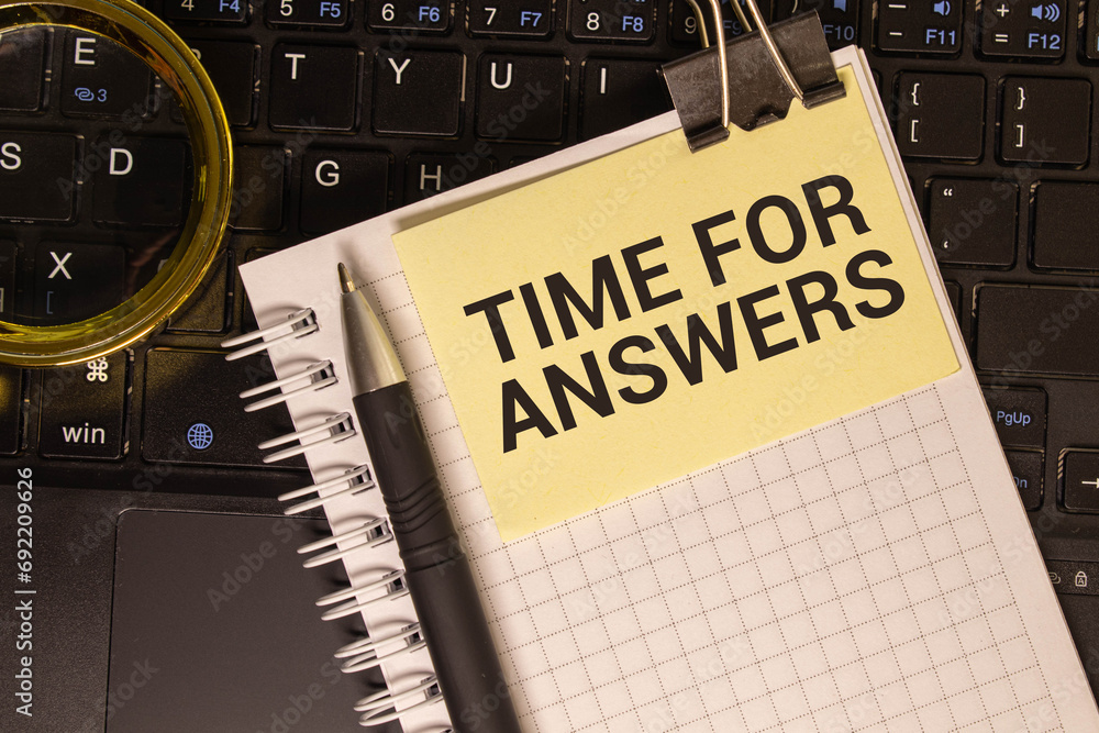 Poster on a pink background, pen and notebook with the text time for answers