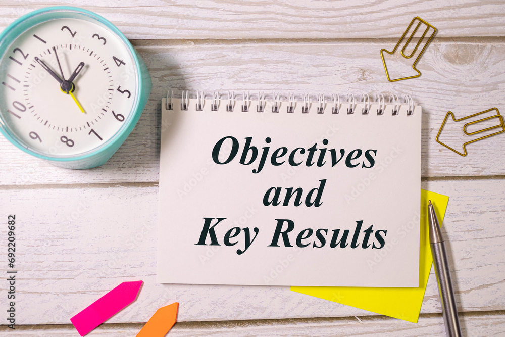 Poster there is notebook with the word objectives key results. it is as an eye-catching image.