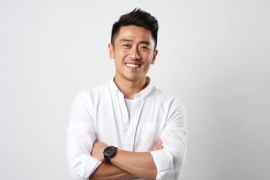 A man in a white shirt standing with his arms crossed. Versatile image suitable for business, confidence, leadership, or professionalism concepts