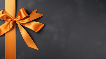 A vibrant Orange gift ribbon with a bow against a gray background - obrazy, fototapety, plakaty