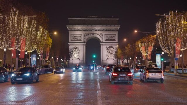Triumphal arch in the evening on the Champs-Elysees in Paris. Time lapse of centre of Paris. Car traffic on a roundabout. Night city lights