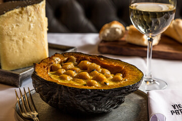 Pumpkin stuffed with gnocchi cheese and a glass of white wine