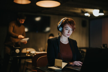A confident businesswoman discussing innovative business strategies in a creative office late at night.