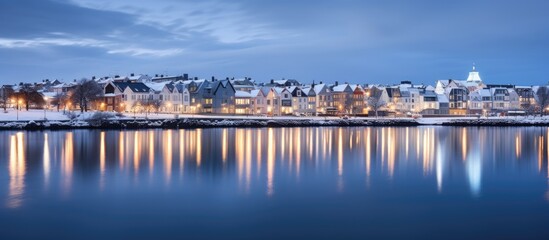 Beautiful houses reflected in lake Tjornin in Reykjavik Iceland during the blue hour in winter. Copy space image. Place for adding text or design - obrazy, fototapety, plakaty