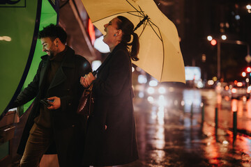 A couple using an ATM on a rainy day. The man withdraws money while holding an umbrella, while the...