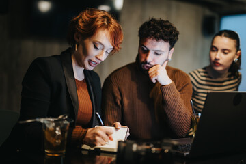 Successful business team coordinating tasks and analyzing sales statistics in corporate office.