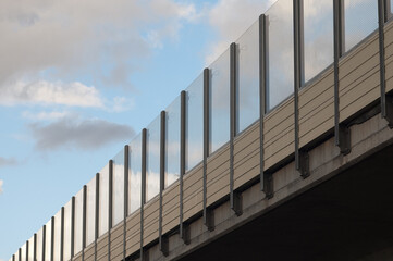 noise insulating transparent shields on the freeway in the background blue sky and clouds