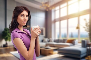 Happy young woman relaxing at home, drinking coffee