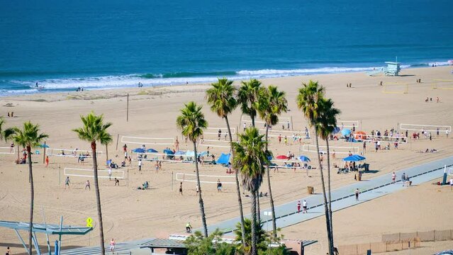 Top view of a sunny beach with basketball nets and a bike path. People relax on Santa Monica Beach, Los Angeles, California