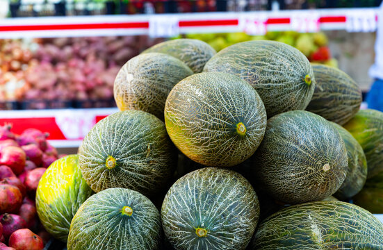 Fresh melons on shelf in supermarket's fruits and vegetables department.