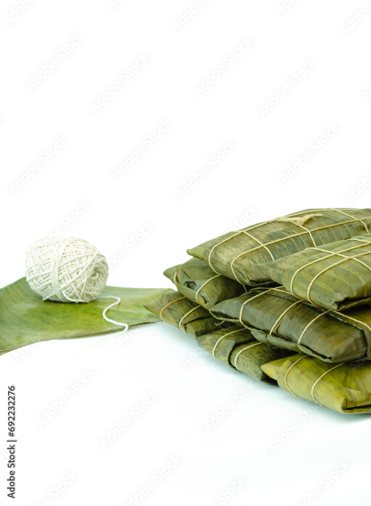 Wall mural Venezuelan hallacas or hayacas wrapped in banana leaves with a roll of wick or pabilo with a white background. Traditional Venezuelan Christmas dish. Typical recipe for Christmas dinner. - Wall murals