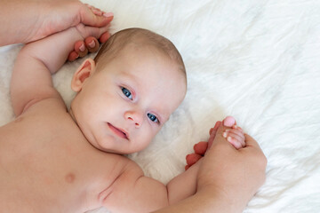 Father's loving hands massage his little infant. 