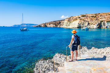 Young woman tourist looking at Rema beach in beautiful sea bay, Kimolos island, Cyclades, Greece - obrazy, fototapety, plakaty