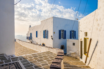 Narrow streets of Plaka village with traditional white houses at sunset time, Milos island,...