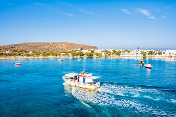 View of boat on sea and Pollonia port houses from deck ferry from Kimolos, Milos island, Cyclades,...