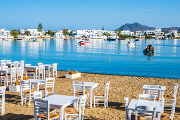 Taverrna chairs and tables on beach in Pollonia port, Milos island, Cyclades, Greece