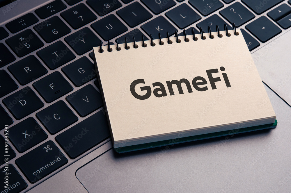 Poster there is notebook with the word gamefi. it is as an eye-catching image.
