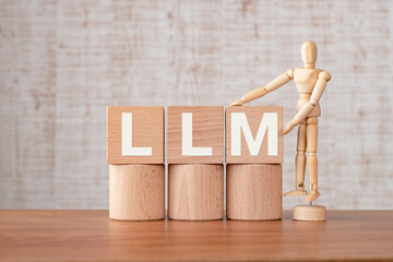 There is wood cube with the word LLM. It is an abbreviation for Large Language Models as...