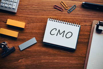 There is notebook with the word CMO. It is an abbreviation for Chief Marketing Officer as eye-catching image.