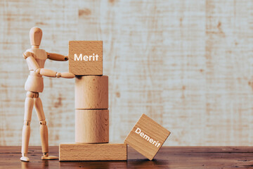 There is wood cube with the word Merit or Demerit. It is as an eye-catching image.