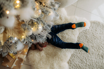 A 5-year-old child climbed under the tree looking for a New Year's gift.