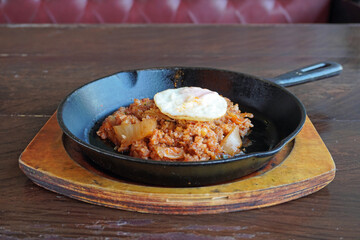 Korean food. Kimchi fried rice served in hot pan with omelette and seaweed tofu soup. Selective focus