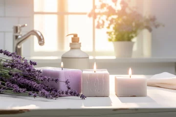 Tuinposter Handmade pastel purple lavender candles in white sunny bathroom. Home made spa, skincare and cosmetology concept. © MNStudio