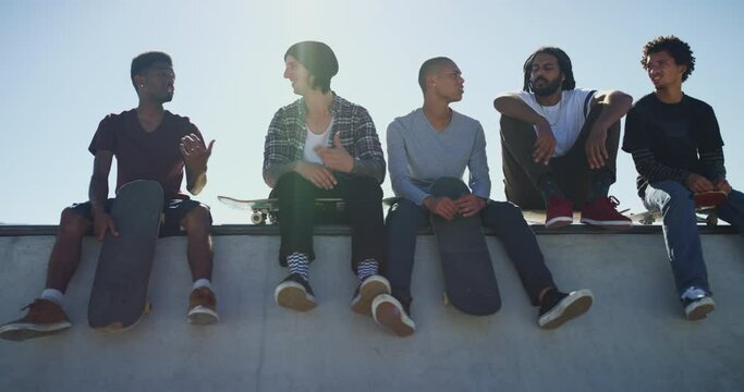 Friends, talking and men with skateboard in city for exercise, practice and hobby activity in town. Diversity, skate park and people skating for adventure, skateboarding and in conversation outdoors