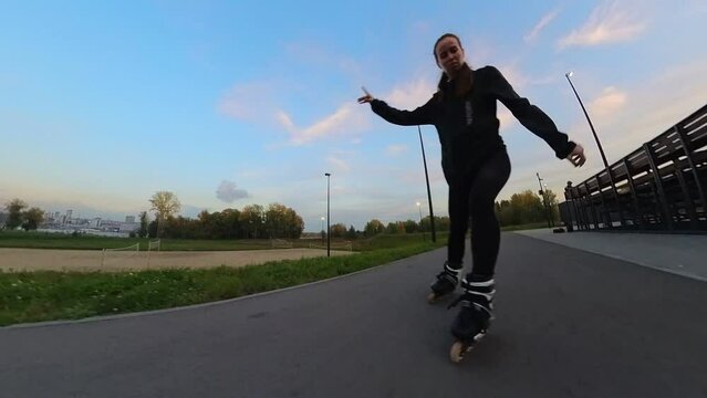 Caucasian woman roller skating in the evening. Slalom. 